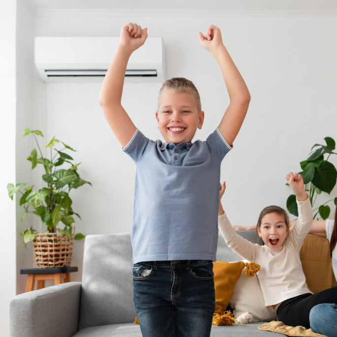 Family of three in a living room with a child cheering.